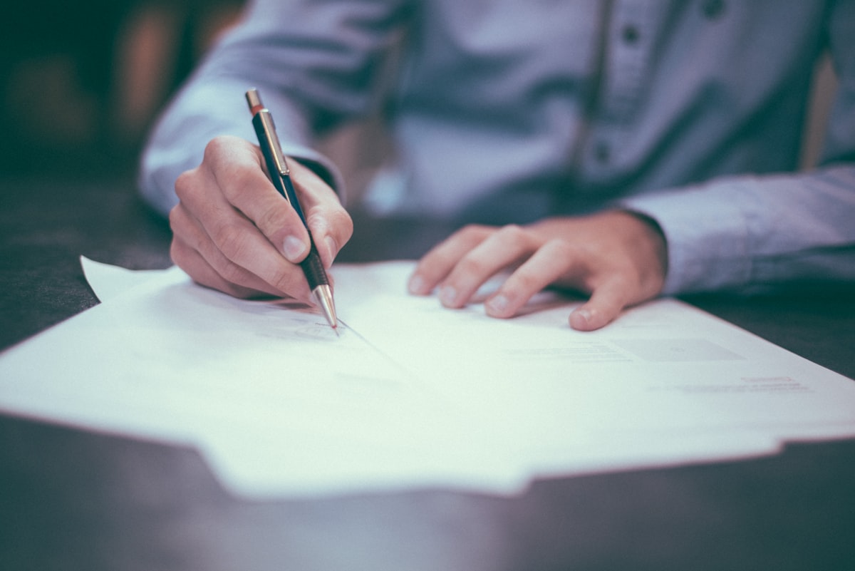 Serious homebuyer signing loan documents with pre-qualification paperwork ready